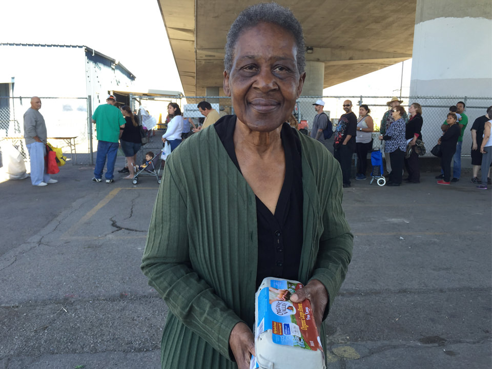 Woman smiling and holding a carton of eggs